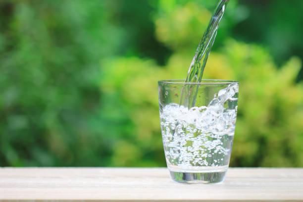 istock Closeup Glass of water on table nature background 842477416