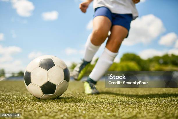 Foto de Menino Chutando A Bola e mais fotos de stock de Futebol - Futebol, Criança, Bola de Futebol