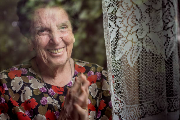 istock Smiling Senior Woman Looking Out Of Window 842480314