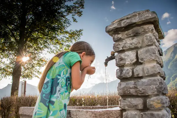 Photo of Girl Drinking Fresh Water From The Village Spring