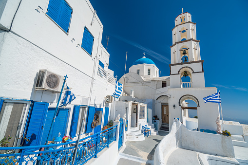 typical greek church and flag in the ancient town of pyrgos on santorini island greece