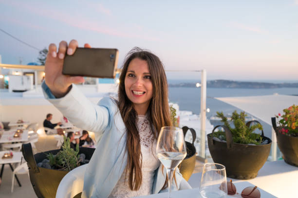 istock happy woman taking selfie picture outside at dining table 842483990