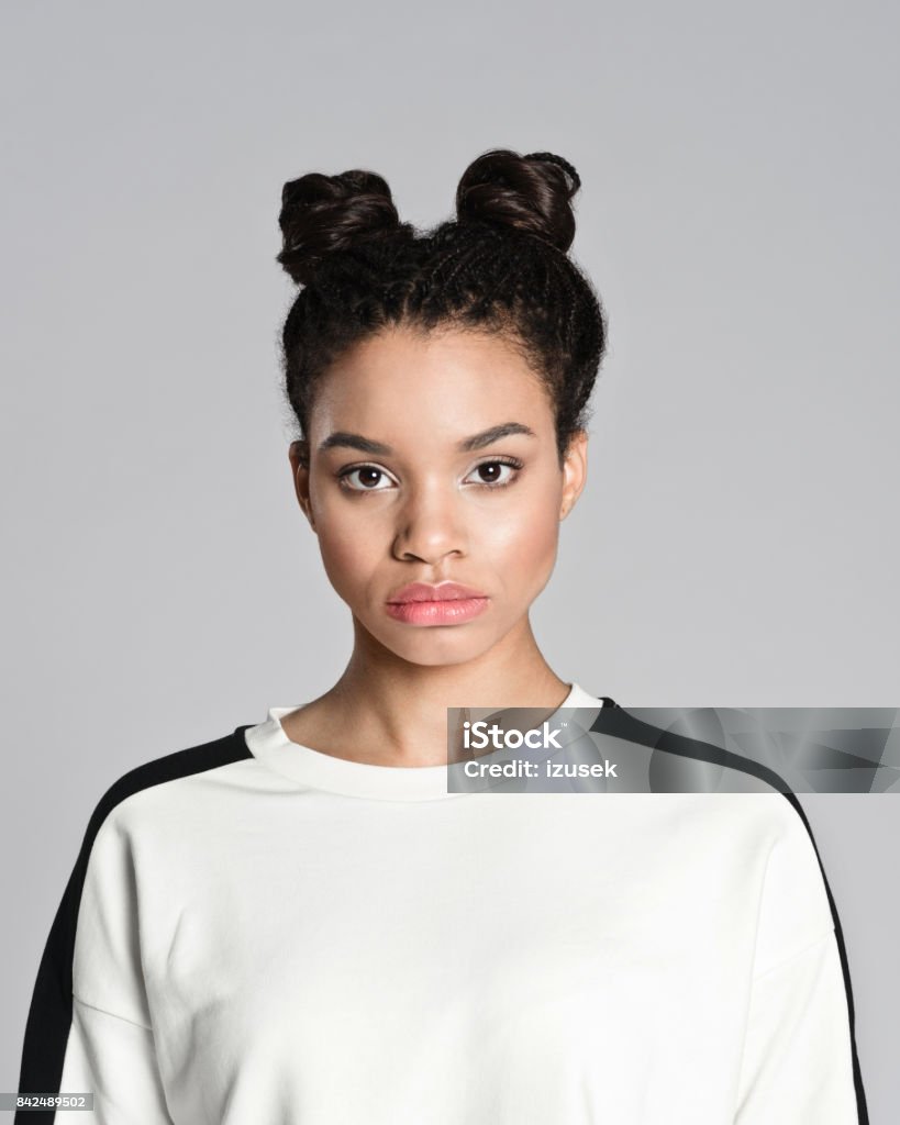 Portrait of afro american teenager woman Studio portrait of afro american teenage woman looking at camera. Studio shot, grey background. African Ethnicity Stock Photo