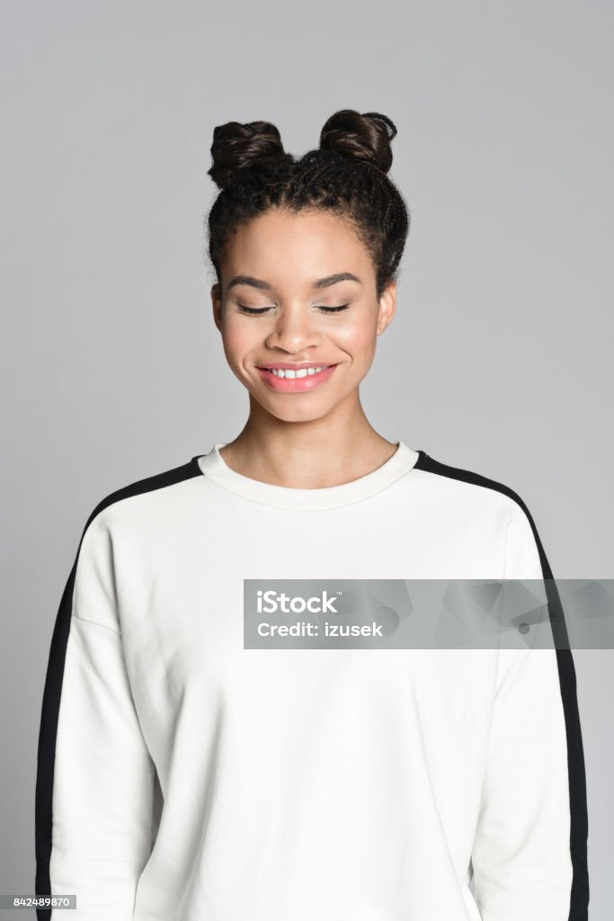 Happy afro american teenager woman Studio portrait of happy afro american teenage woman smiling with eyes closed. Studio shot, grey background. 16-17 Years Stock Photo