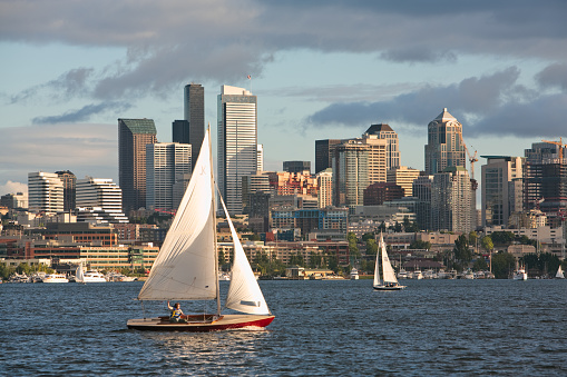 Seattle, WA, USA Oct 9, 2008: Red sail boat with white sails on Lake Union with the city of Seattle, Washington in background
