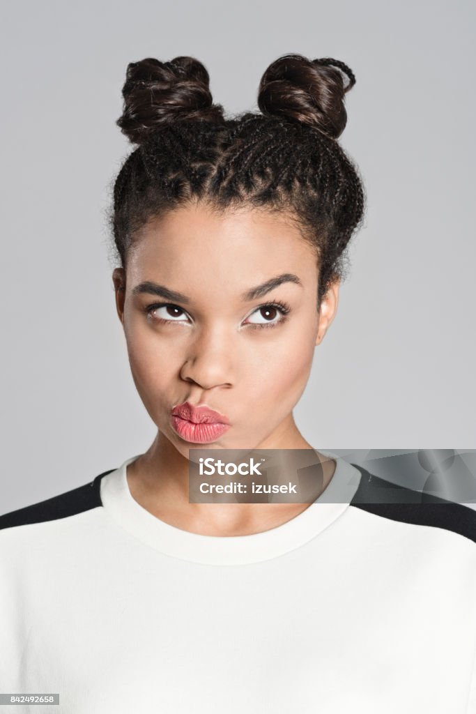 Doubtful afro american teenager girl Studio portrait of afro american teenage woman making a decision. Studio shot, grey background. Human Face Stock Photo