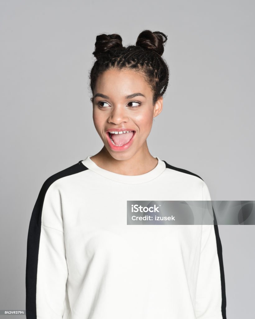 Excited afro american teenager girl Studio portrait of happy afro american teenage woman laughing. Studio shot, grey background. Teenager Stock Photo