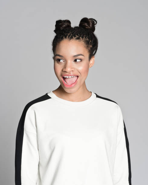 Excited afro american teenager girl Studio portrait of happy afro american teenage woman laughing. Studio shot, grey background. hair bun stock pictures, royalty-free photos & images