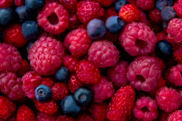 closeup foto fresca colorida mezcla de berries: arándanos, frambuesas y fresas silvestres - blueberry fruit berry fruit food fotografías e imágenes de stock