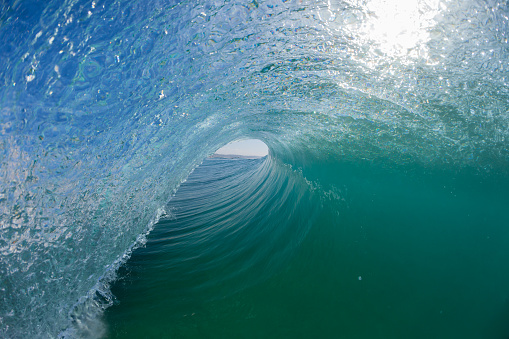 Ocean wave power surfing surfer view inside out hollow crashing tube.