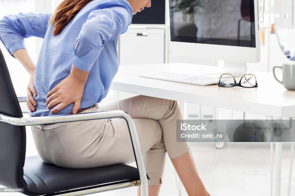 Businesswoman with pain in back Backache Stock Photo