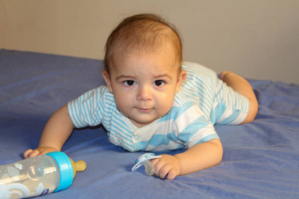 istock Five months old baby boy playing with bottle on the bed 842597222