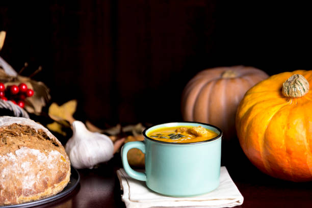 istock Autumun pumpkin soup in a mug with home mad bread 842599912