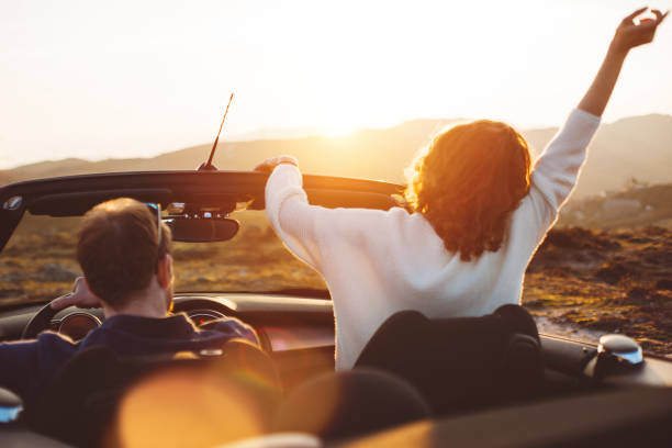 istock Happy couple looking at sunset from convertible 842605516