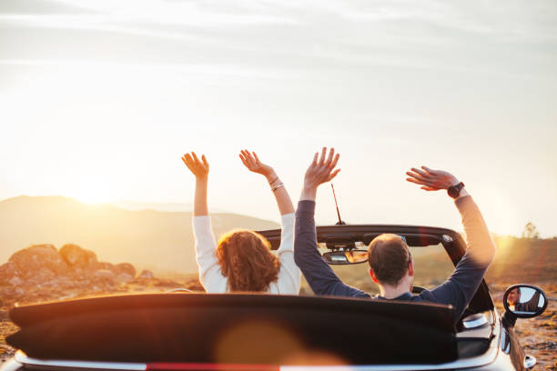 istock Happy couple looking at sunset from convertible 842605520
