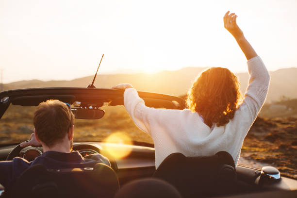istock Happy couple looking at sunset from convertible 842605522