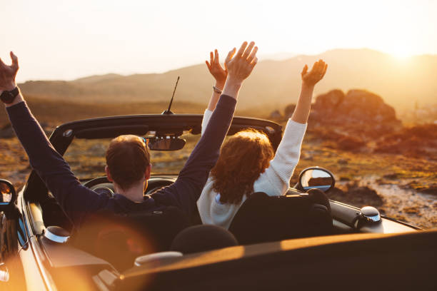 istock Happy couple looking at sunset from convertible 842605636