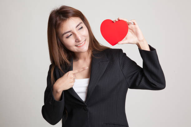istock Asian woman point to red heart. 842605938