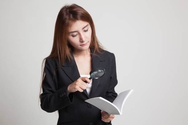 istock Asian woman with a book and magnifying glass. 842606722