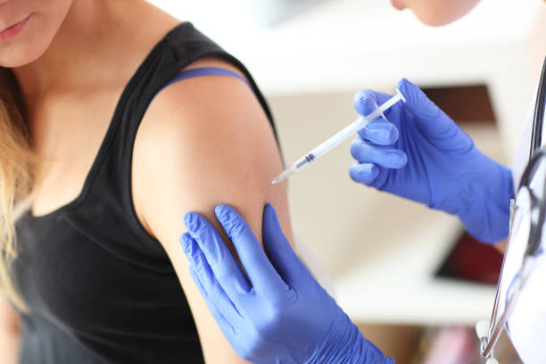 Young doctor giving a patient injection.