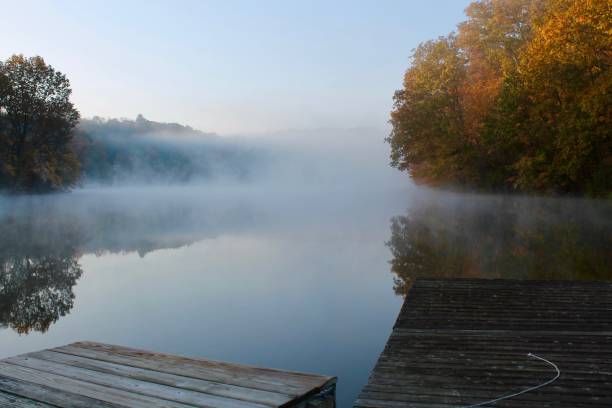 Brilliant autumn foliage reflected in mist-shrouded lake, Katonah, NY