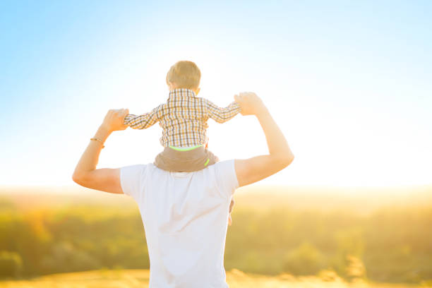 istock Father with his son sitting on his neck over sunset 842624490