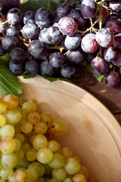 istock Grapes on wooden background, white and black top view 842626552