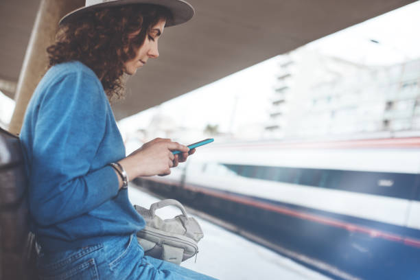 istock Woman with smartphone waiting for a train on railway station 842629186