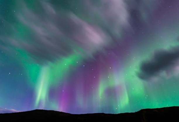 istock Green and purple Aurora borealis over silhouetted foreground 842635442