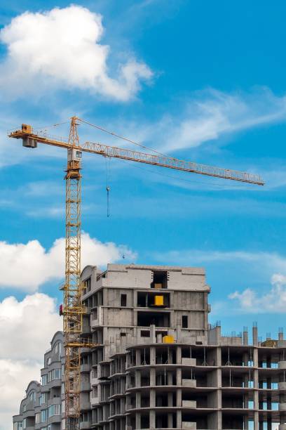 istock A large crane on a construction site against a blue sky with clouds. 842644152