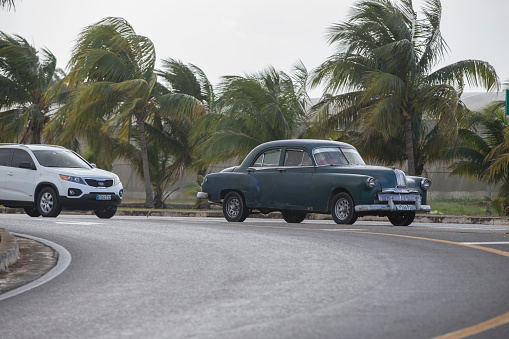 Car on the street of Havana. Palm treets on the background.