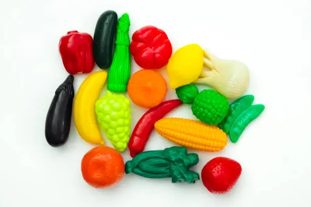 Photo of Group of vegetable and fruit plastic toys for children in isolated white background