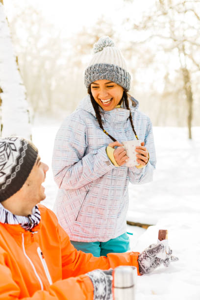 istock Couple drinking hot drinks in winter park 842677280