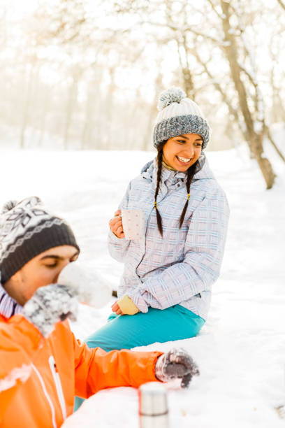 istock Couple drinking hot drinks in winter park 842677294