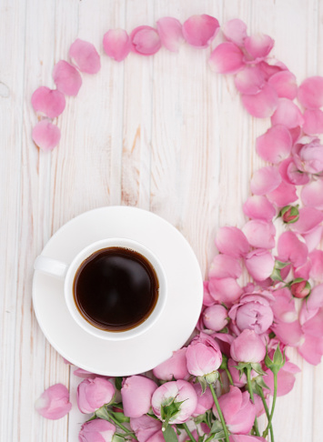 Pink rose flower and coffee on pastel background. Flat lay