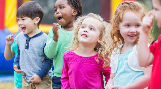 istock Multi-ethnic children playing in park, by bounce house 842689098