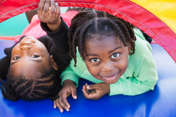 dwoje dzieci bawiących się w domu bounce - preschooler african ethnicity little girls child zdjęcia i obrazy z banku zdjęć