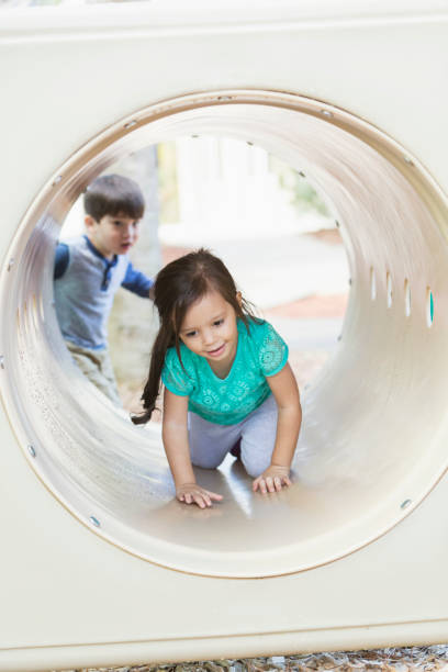 istock Girl crawling through tunnel on playground 842689176