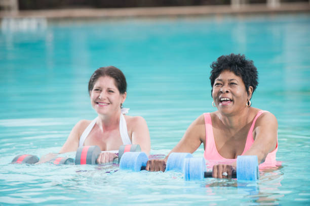 istock Two mature multi-ethnic women doing water aerobics 842689536