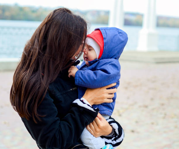 istock mother holding baby outdoors in autumn 842690396