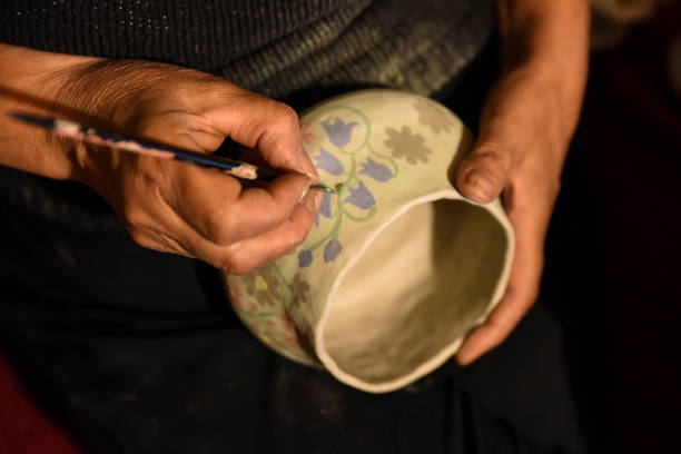 paint a ceramic plate. Do it yourself. Hand made crockery. Drawing with a brush on clay ceramics. Hand-painting homemade dishes. Potter Prepare Paints Dye Clay Plate Workshop, Top View, Close-Up