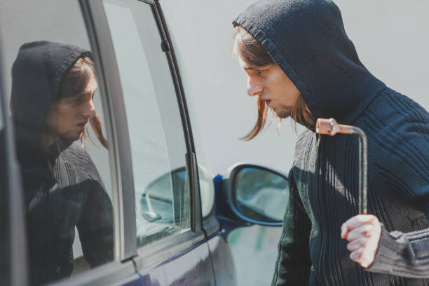 istock Thief burglar breaking smashing the car window 842726288