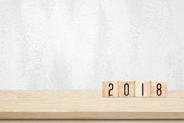 istock Wooden cubes with 2018 on table over white wall background, new year banner 842726780