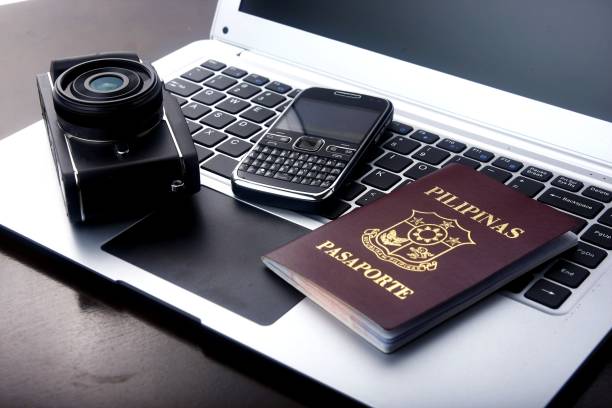 Camera, passport and cellphone on a laptop computer. stock photo