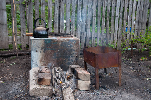 istock hiking kitchen for a shish kebab. brazier, bricks, bonfire, coals, kettle on the background of an old wooden fence 842743366