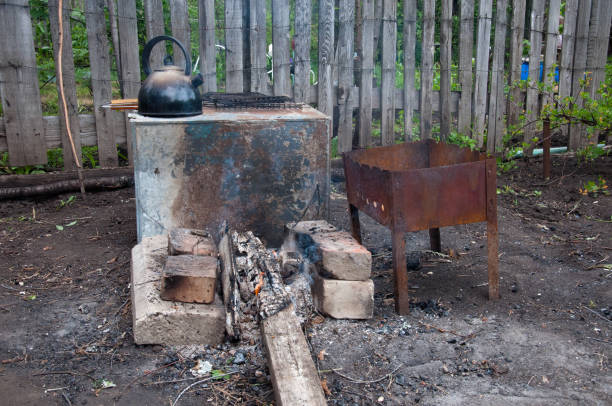 istock hiking kitchen for a shish kebab. brazier, bricks, bonfire, coals, kettle on the background of an old wooden fence 842743812