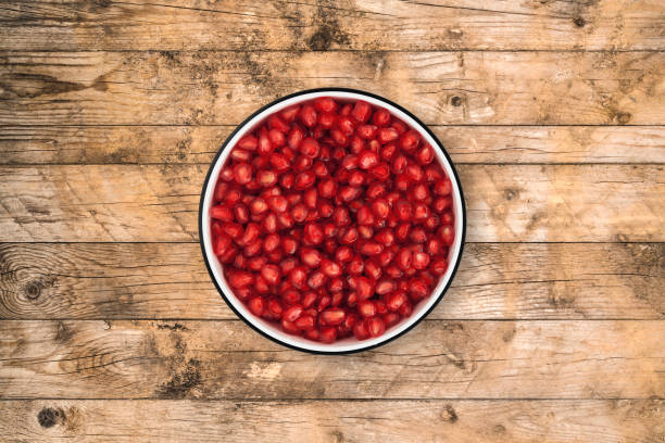 istock Pomegranate seeds bowl on wood background from directly above 842748026