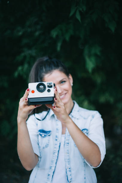 istock Girl smiling and holding old camera 842756176