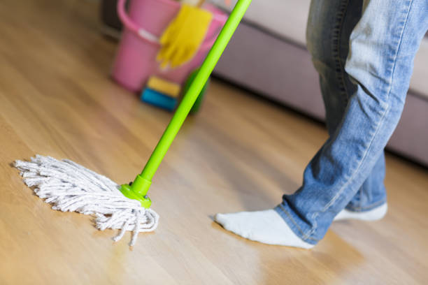 istock woman in protective gloves using a wet-mop while cleaning floor 842767782