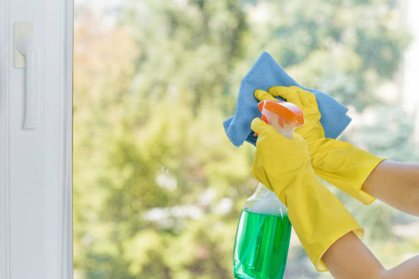 istock Woman cleaning window with blue cloth. 842769184